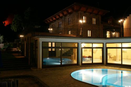 Blick auf die Terrasse mit Swimmingpool am Abend mit den Innenlichtern, die sich während des Ätna-Ausbruchs spiegeln