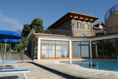 Terrasse mit Swimmingpool und Liegestühlen an einem sonnigen Sommertag