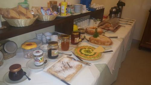 Blick auf das Frühstücksbuffet mit Kuchen, Croissants, Säften, Milch, Brot, Müsli und Honig